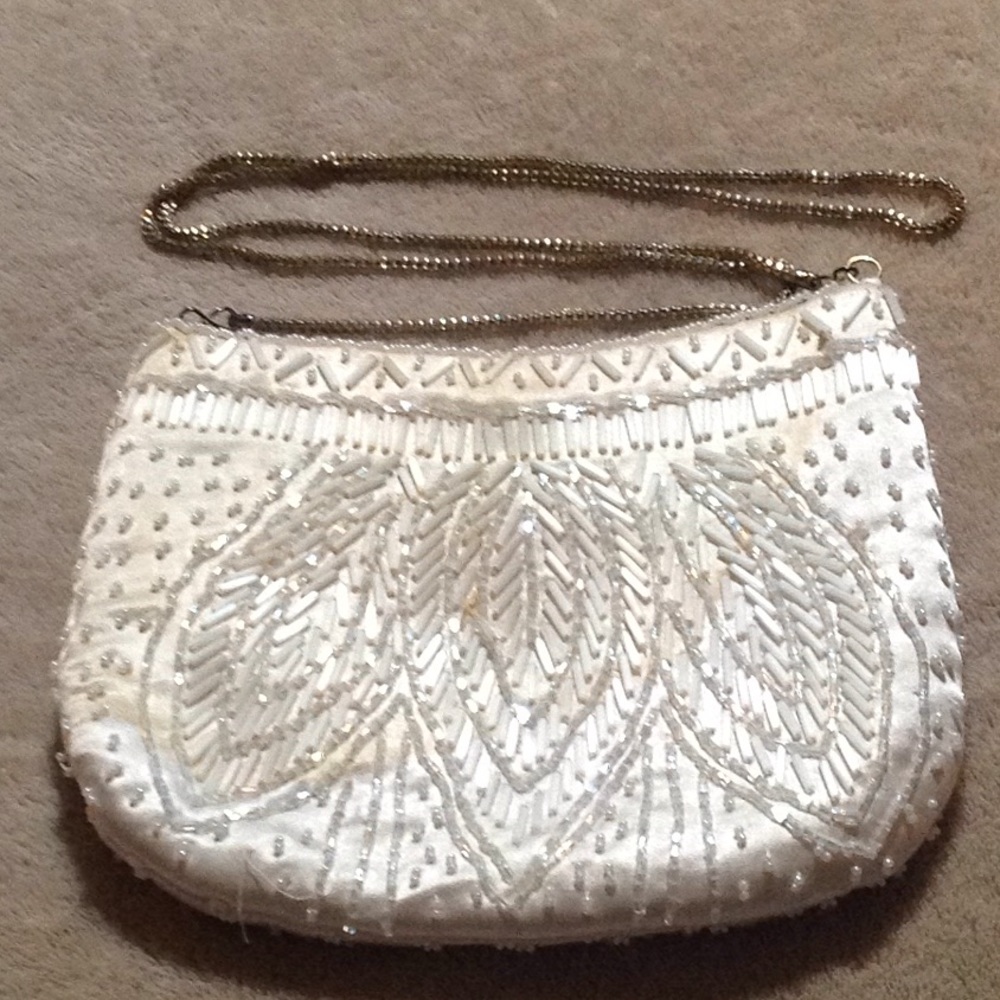 Off white beaded bag, chain strap & snap closure.